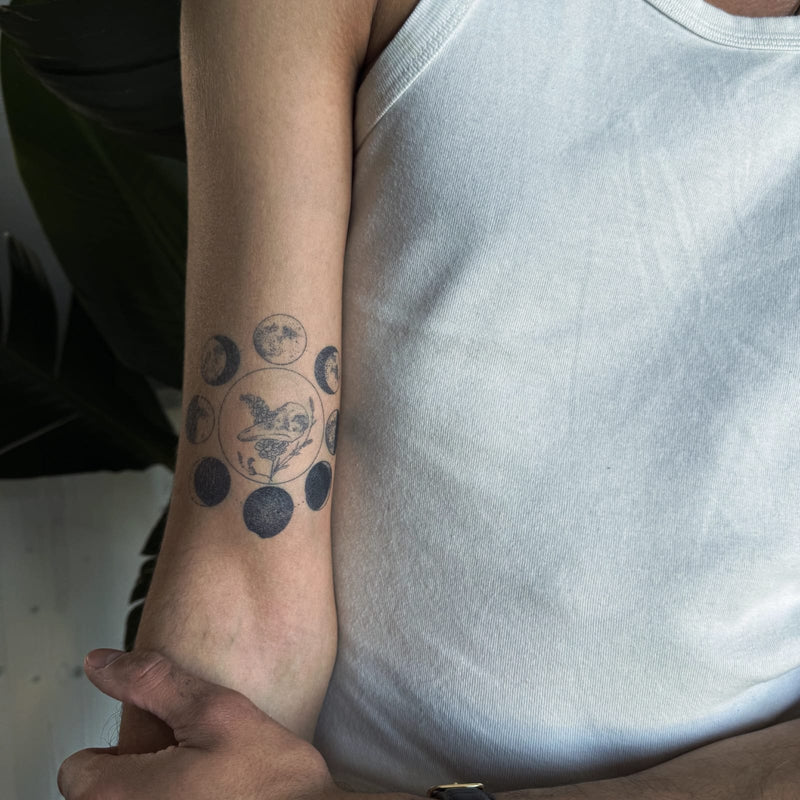 Moon phases 2-week tattoo on a forearm