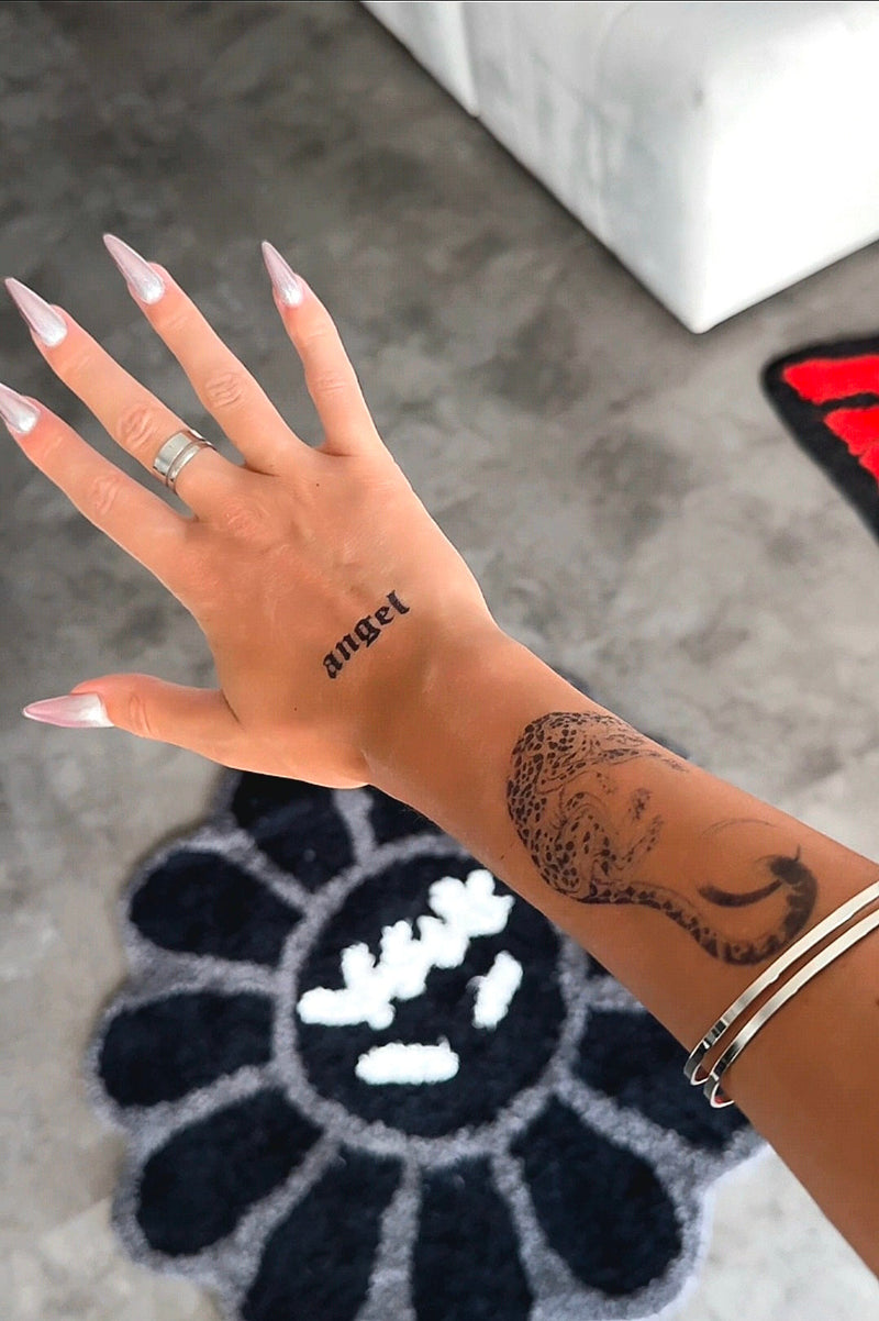 Hand with the word angel as a script lettering tattoo